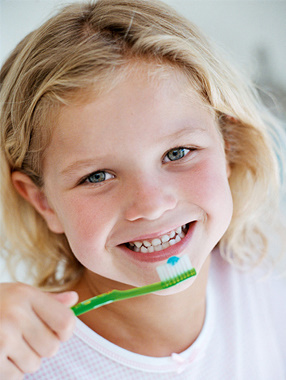 young girl brushing teeth