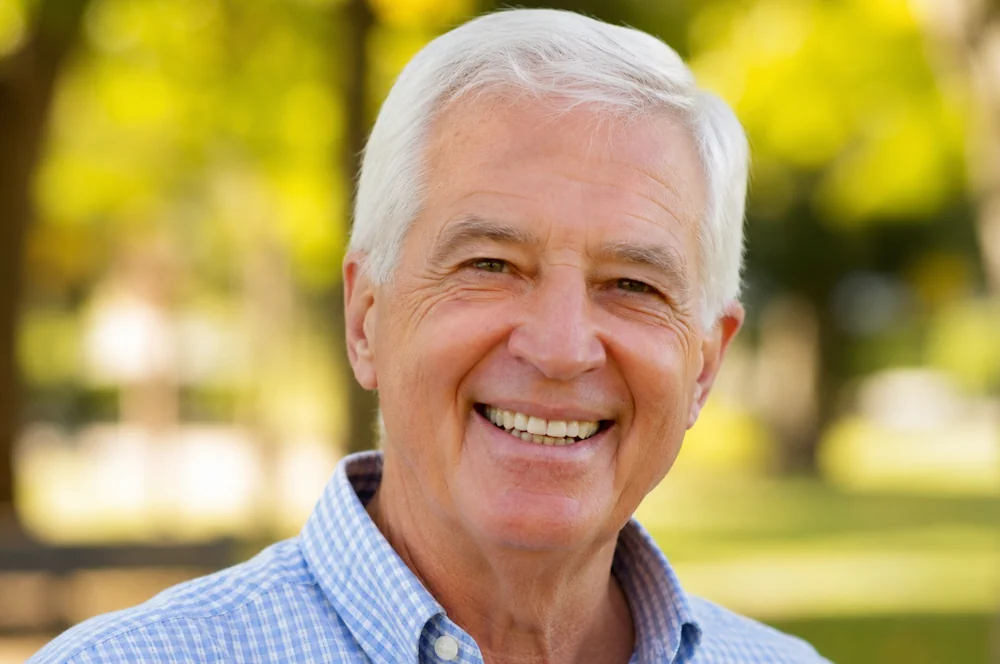 smiling senior in sunlit park 